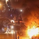 Protesters in Iran during nationwide demonstrations with security forces in the background