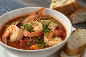 Louisiana Court-Bouillon seafood stew with white fish, tomatoes, and lemon slices served in a bowl