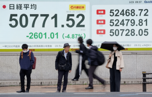 Pedestrians near Nikkei board in Tokyo as Asia stocks slide US Iran war tension