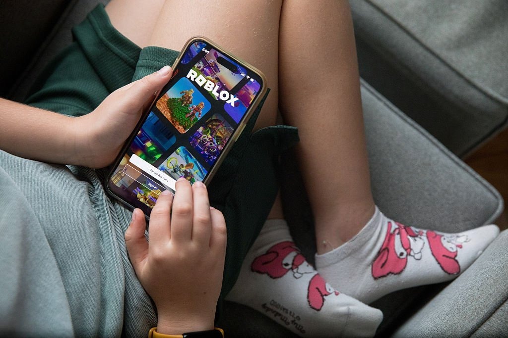 Parents monitoring children playing Roblox on a computer for online safety