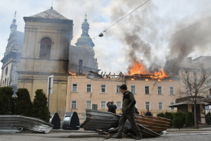 Man walks past burning building after Russian drone attack in Lviv Ukraine