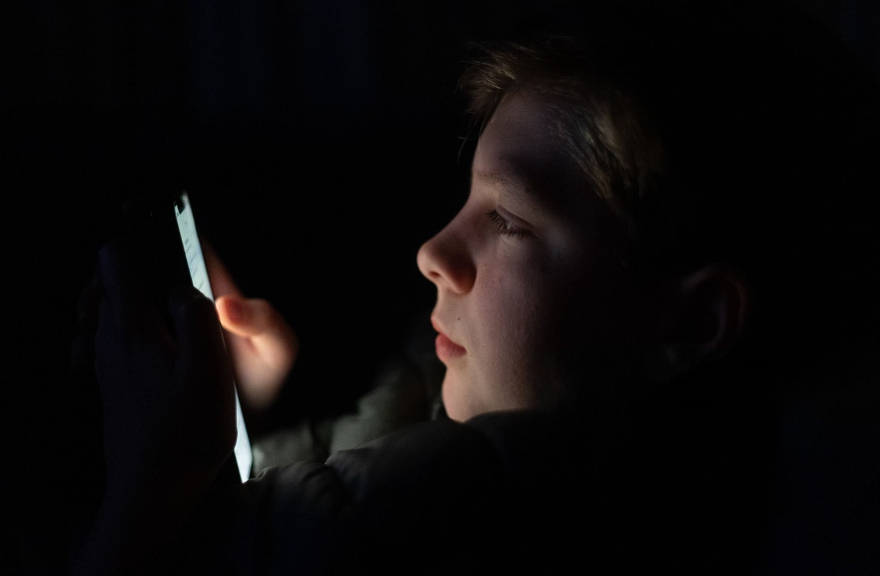 12-year-old boy using smartphone under social media restrictions reflecting EU child online safety and age verification rules