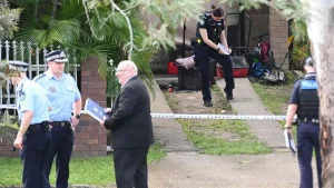Multiple police vehicles and officers at the scene in Arana Hills, north Brisbane, secured with police tape during a welfare call shooting incident on April 1, 2026.